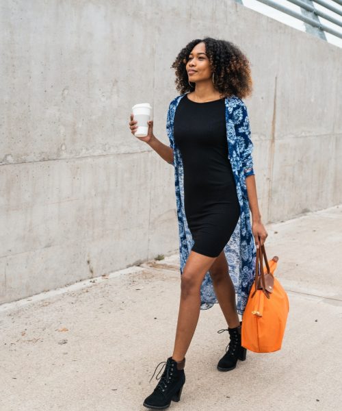 Afro american woman walking with coffee.